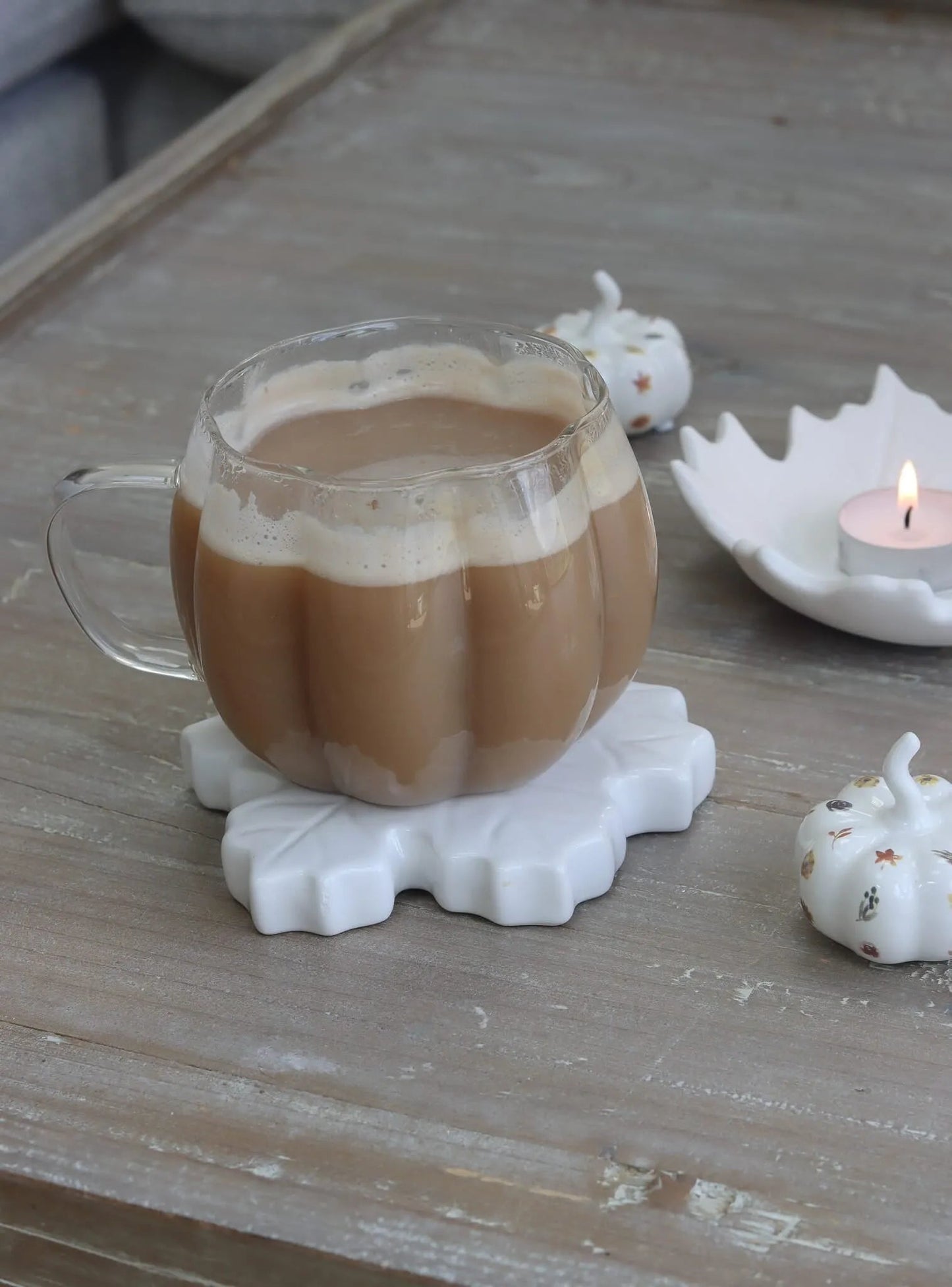 Tasse citrouille en verre sur table en bois avec déco automne