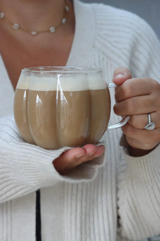 Tasse citrouille en verre borosilicaté tenue dans les mains
